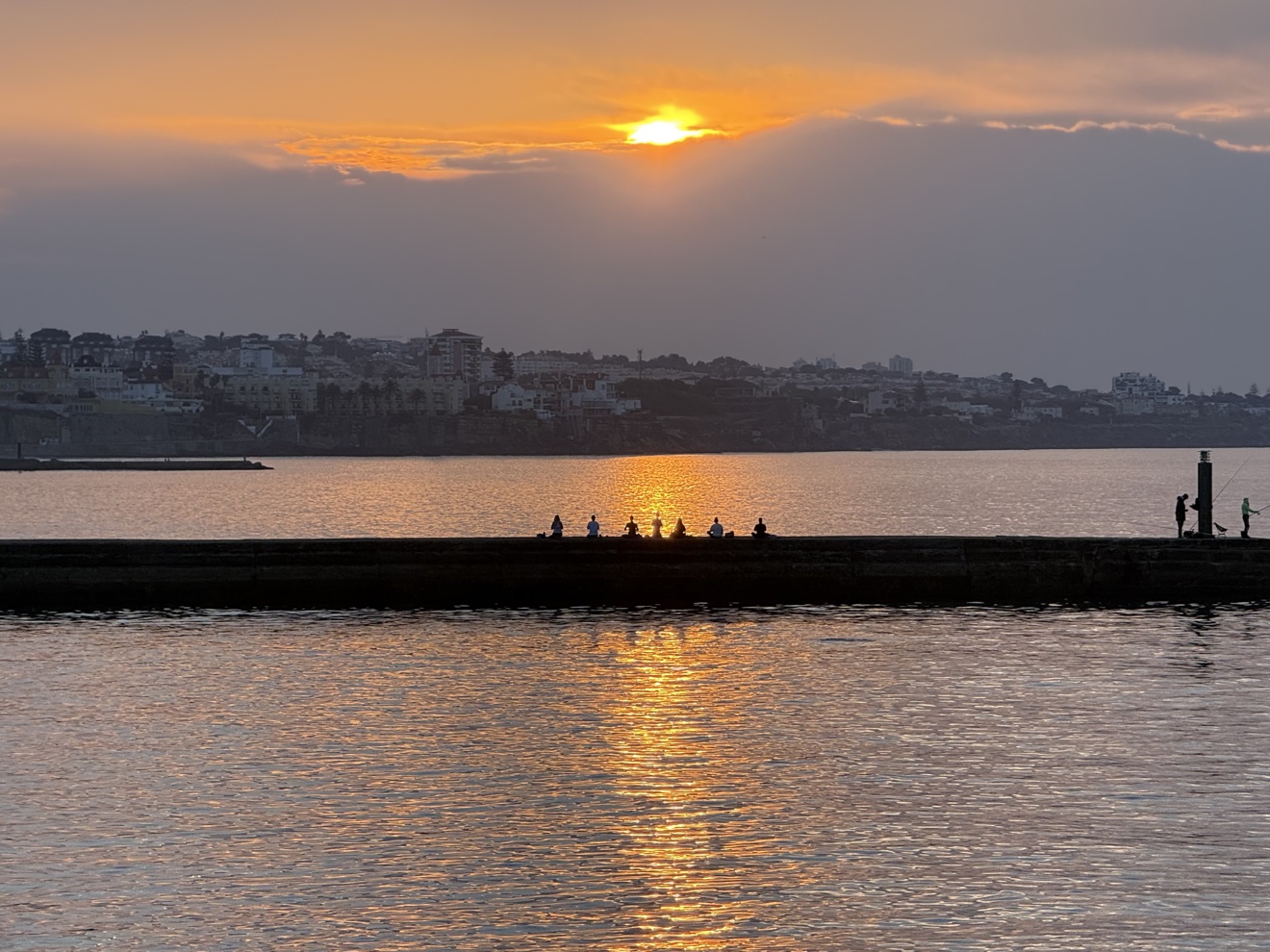 Sunset over Cascais, fishermen on the pier